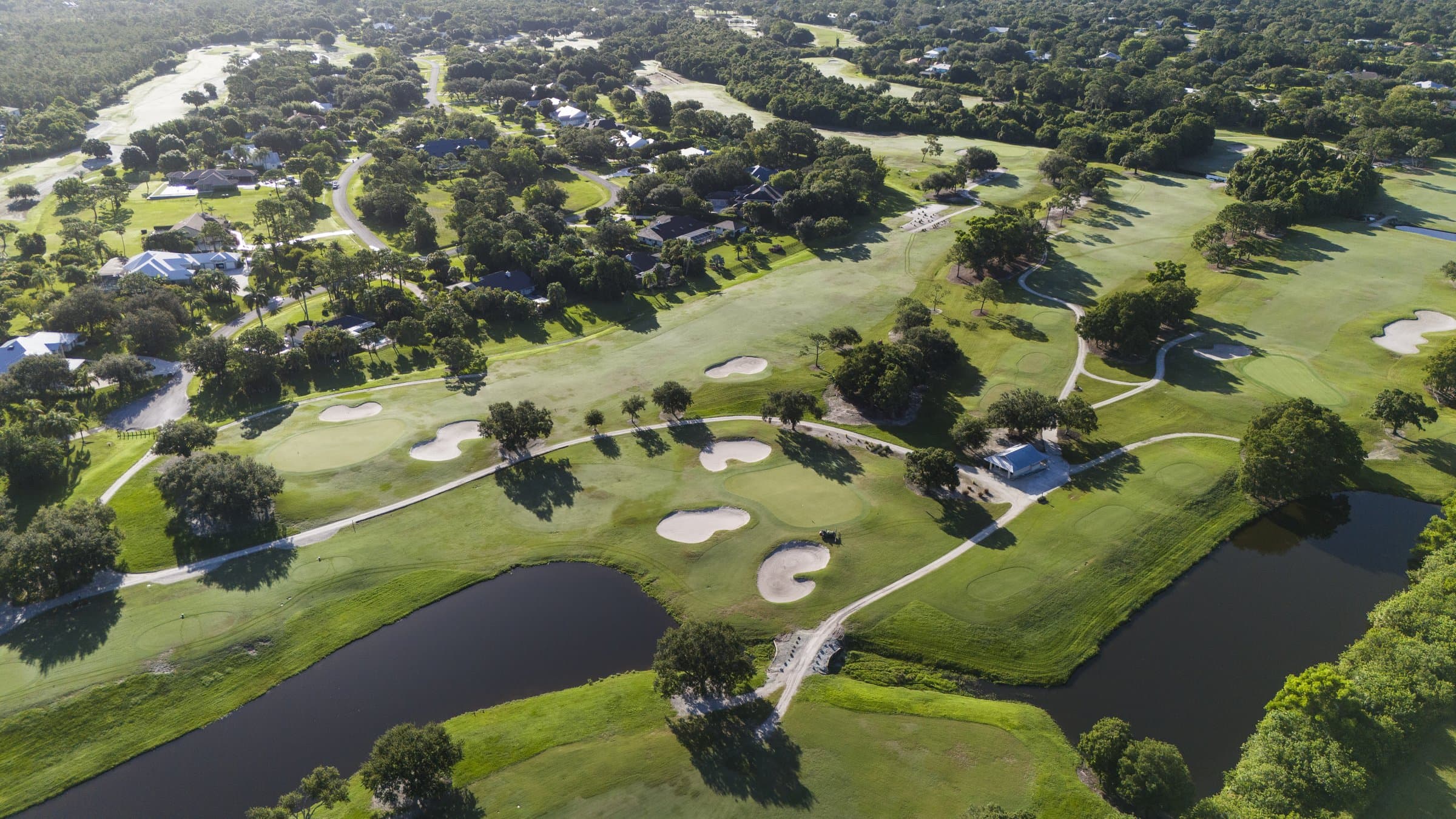 Aerial view of Banyan Creek Golf Club fairways, bunkers, and lakes in Palm City